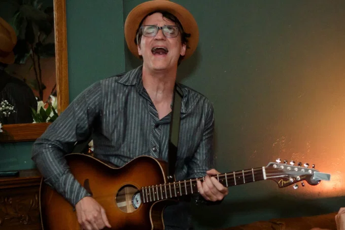 Happy Montana singing and playing acoustic guitar during a live session